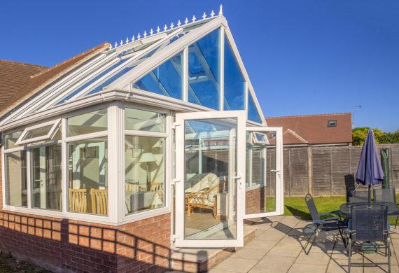 A conservatory in the summer with the doors open