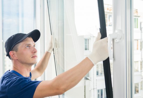 Worker fitting a window with a smile on his face